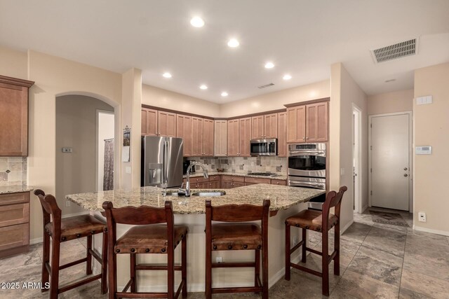 4615 S Primrose Dr, Gold Canyon, AZ 85118 - kitchen with visible vents, appliances with stainless steel finishes, tasteful backsplash, arched walkways, and a sink