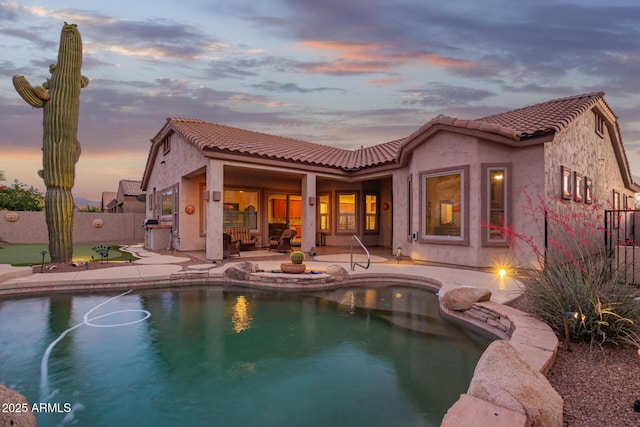 4615 S Primrose Dr, Gold Canyon, AZ 85118 - back of property at dusk with stucco siding, a tiled roof, and fence