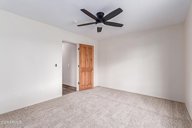 carpeted spare room featuring ceiling fan