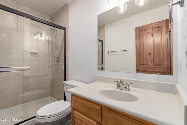 bathroom featuring vanity, toilet, and a shower with door