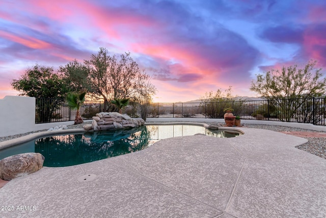 pool at dusk with a patio