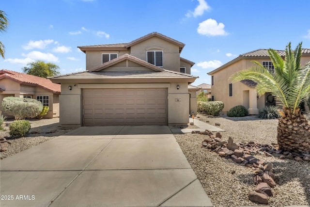 view of front of home with concrete driveway, a tiled roof, an attached garage, and stucco siding