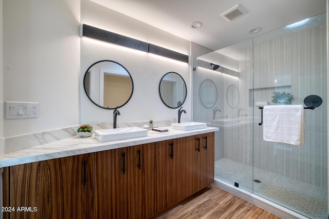 bathroom with hardwood / wood-style flooring, vanity, and a shower with door