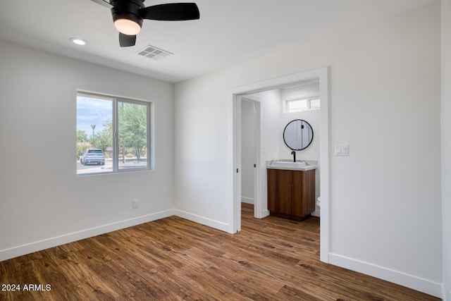 unfurnished bedroom with ceiling fan, dark hardwood / wood-style flooring, and sink