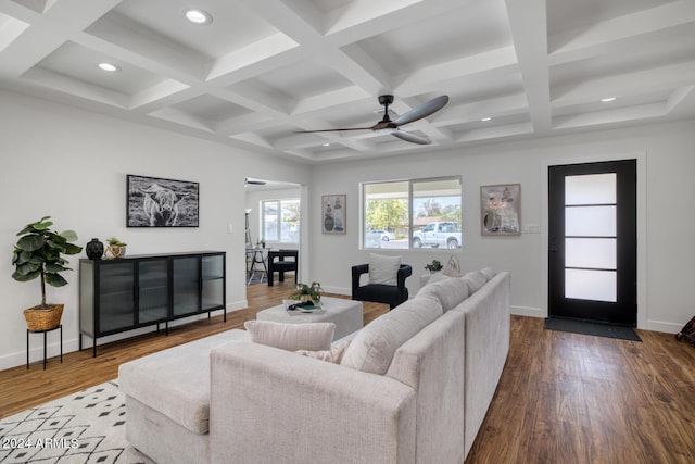 living room with hardwood / wood-style flooring, ceiling fan, and beamed ceiling