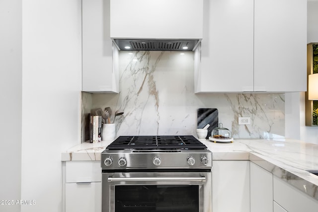 kitchen with white cabinetry, range hood, light stone counters, and stainless steel gas stove