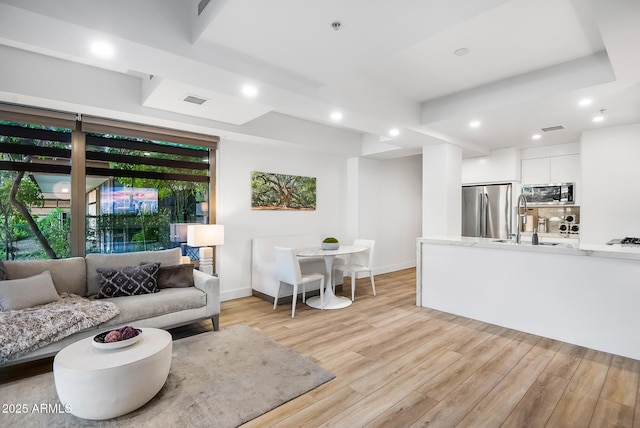 living room with sink and light hardwood / wood-style floors