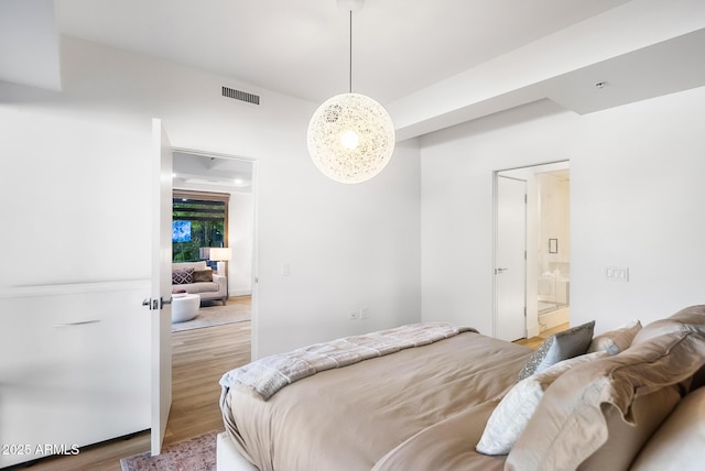 bedroom featuring hardwood / wood-style flooring and ensuite bath