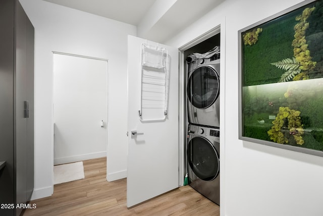 clothes washing area with stacked washer and dryer and light hardwood / wood-style floors