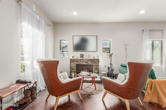 sitting room with wood finished floors, recessed lighting, and a fireplace