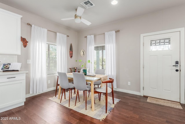 dining room featuring plenty of natural light, dark wood-style floors, visible vents, and baseboards