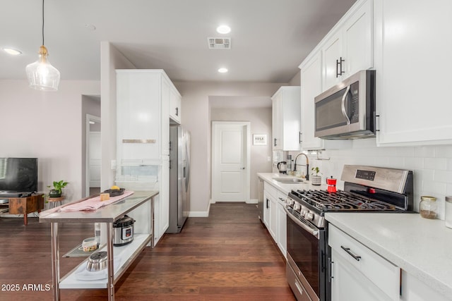 kitchen featuring visible vents, a sink, light countertops, white cabinets, and appliances with stainless steel finishes