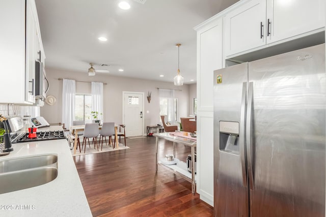 kitchen featuring a sink, light countertops, stainless steel appliances, white cabinetry, and dark wood-style flooring