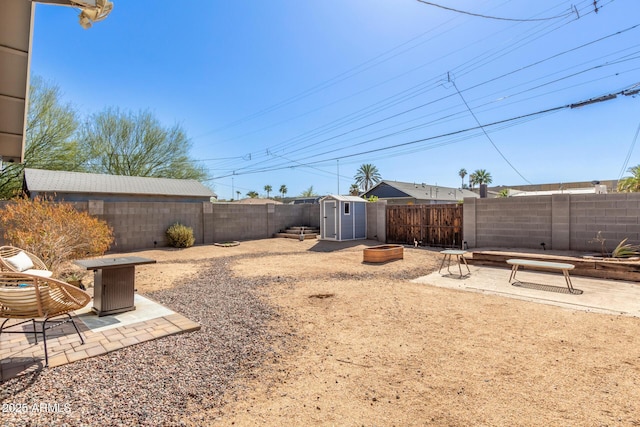 view of yard with a storage unit, a fenced backyard, an outdoor structure, and a patio