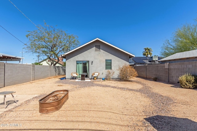 rear view of house featuring a patio area, a fenced backyard, and stucco siding