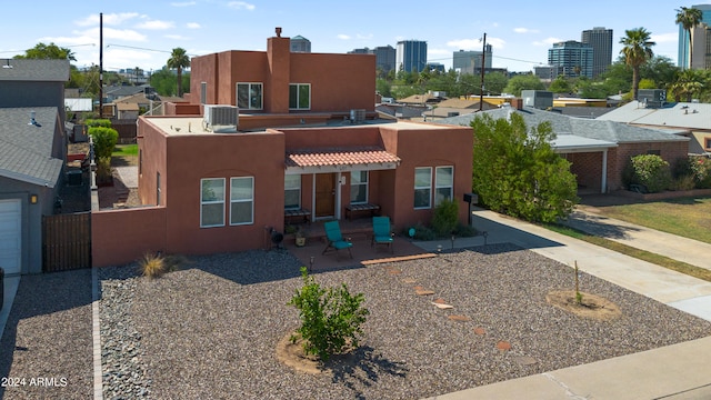 adobe home with a patio and central AC unit