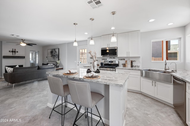 kitchen featuring white cabinets, ceiling fan, light stone countertops, and stainless steel appliances