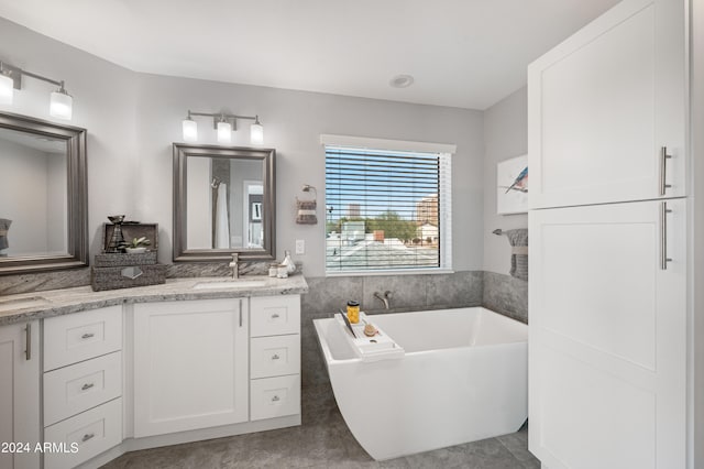 bathroom with tile patterned flooring, vanity, and a tub to relax in