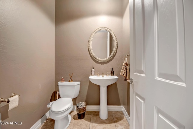 bathroom featuring toilet and tile patterned flooring