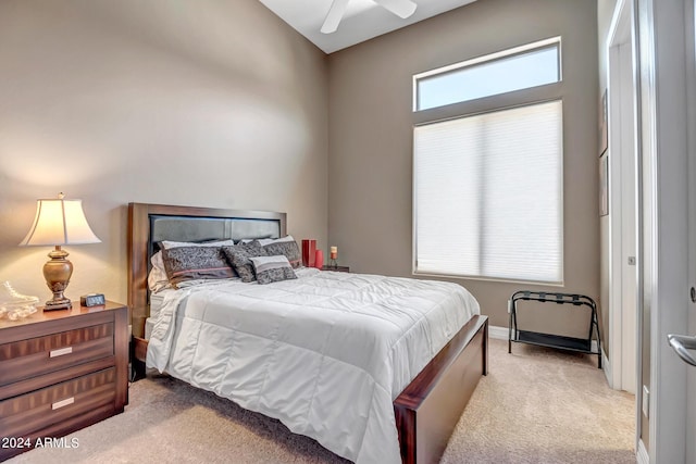 bedroom featuring light carpet, ceiling fan, and baseboards