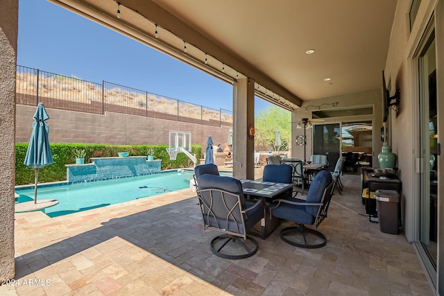 view of patio / terrace featuring outdoor dining space, fence, and an outdoor pool