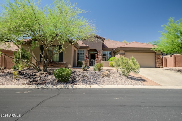 view of front of house featuring a garage, concrete driveway, a tile roof, and stucco siding