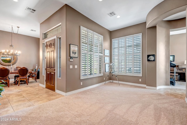 entrance foyer with light colored carpet and a chandelier