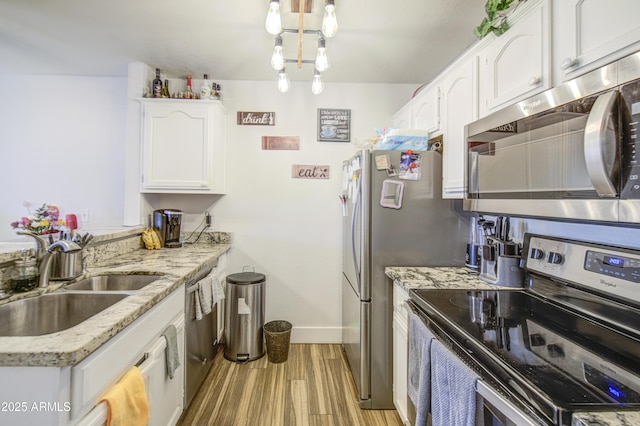 2301 E University Dr Unit 488, Mesa, AZ 85213 - kitchen featuring stainless steel appliances, a sink, white cabinets, light stone counters, and baseboards