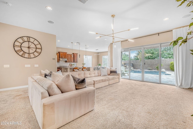 living room featuring an inviting chandelier, recessed lighting, light colored carpet, and baseboards