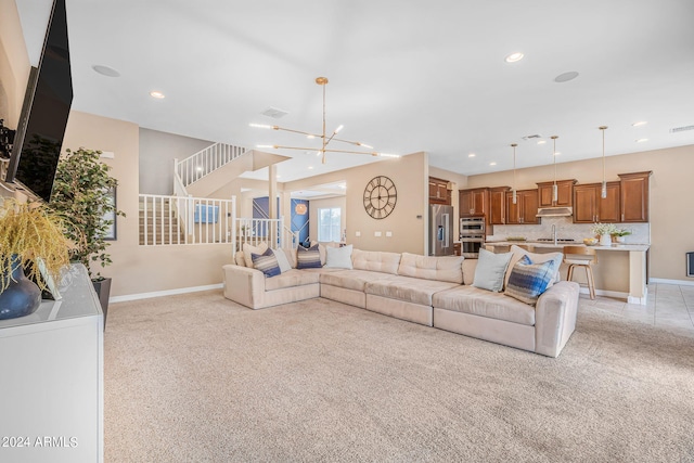 living area with baseboards, light carpet, and stairs