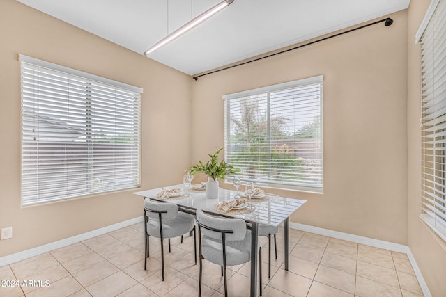 dining area featuring light tile patterned floors, baseboards, and a healthy amount of sunlight