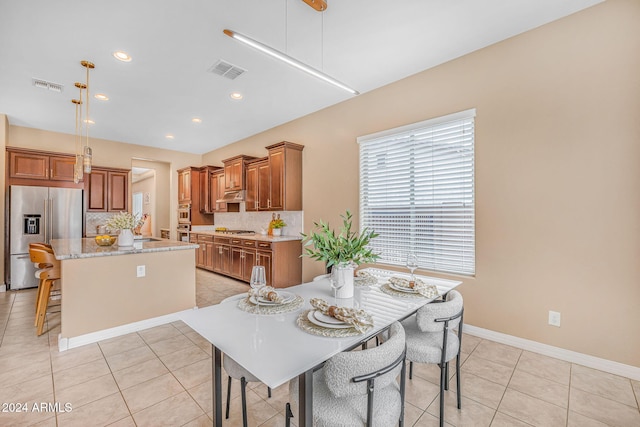 dining space featuring light tile patterned floors, baseboards, and visible vents