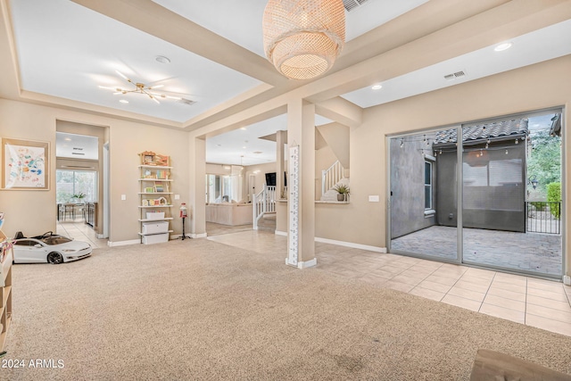 interior space featuring tile patterned flooring, visible vents, a chandelier, and a tray ceiling