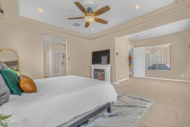 bedroom featuring visible vents, baseboards, a glass covered fireplace, and carpet flooring