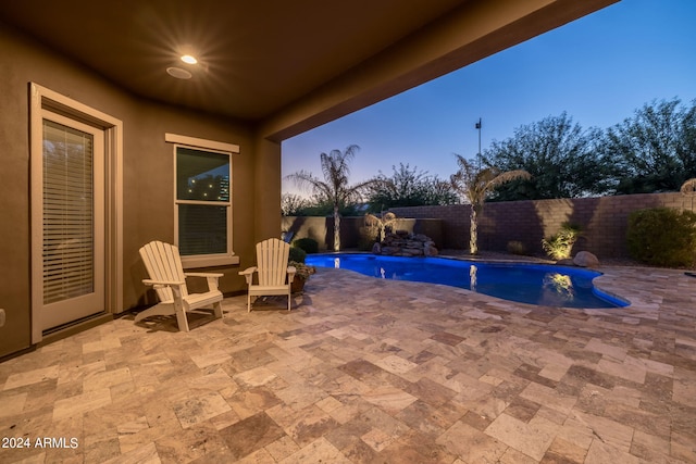 pool at dusk featuring a patio area, a fenced in pool, and a fenced backyard