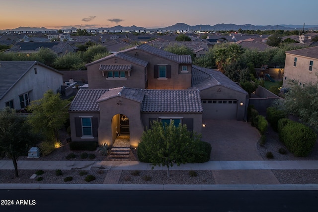 mediterranean / spanish home with a garage, a residential view, a mountain view, and a tiled roof