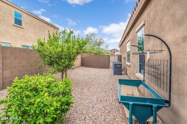 view of yard with central air condition unit and a fenced backyard