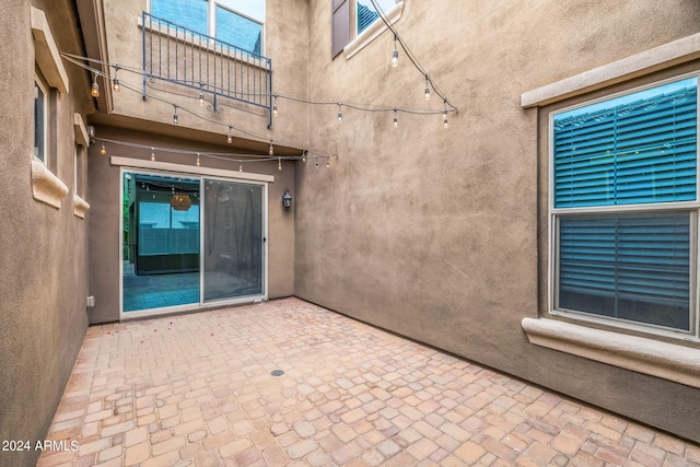 view of exterior entry with stucco siding and a patio area