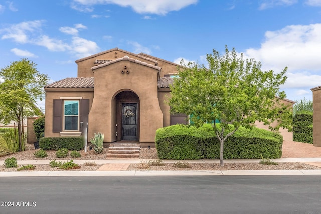 mediterranean / spanish house with stucco siding and a tile roof