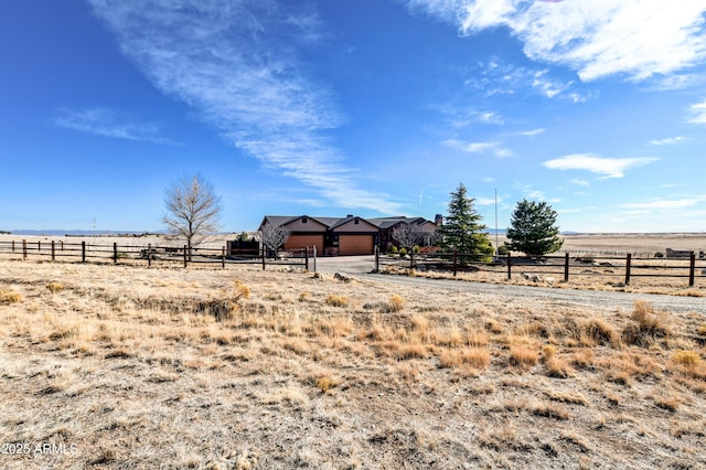 view of yard featuring fence and a rural view