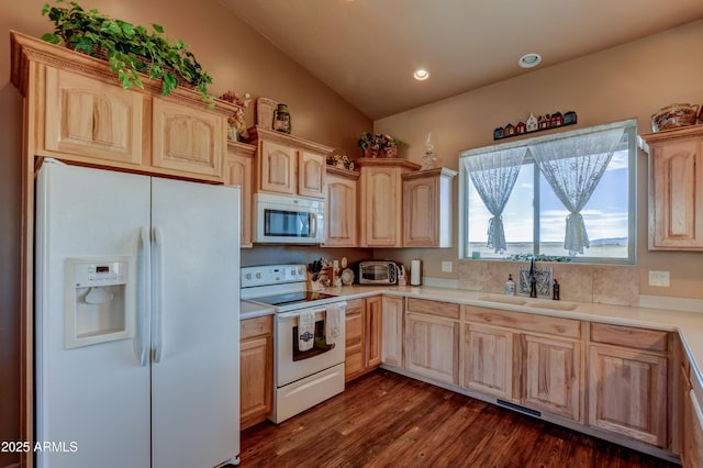 kitchen featuring white appliances, light brown cabinetry, light countertops, and a sink