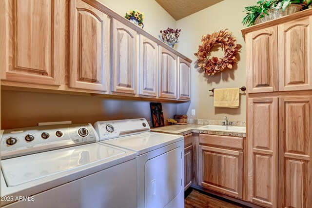 washroom with washing machine and dryer, cabinet space, and a sink