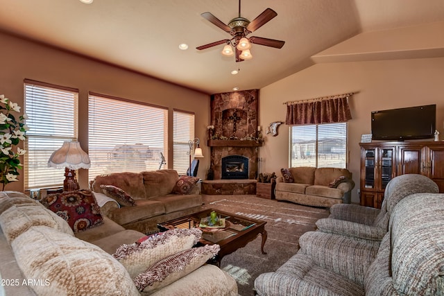 living room featuring a stone fireplace, vaulted ceiling, and ceiling fan