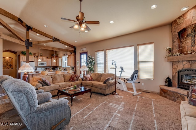 carpeted living area featuring beamed ceiling, baseboards, recessed lighting, a ceiling fan, and a stone fireplace
