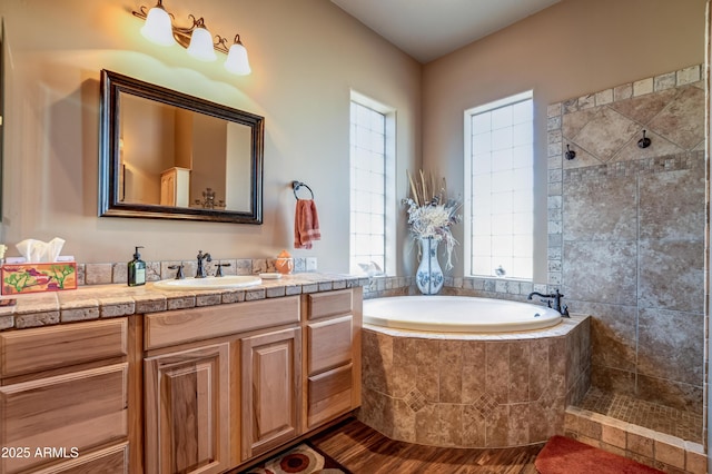 full bath with vanity, a tile shower, and a bath