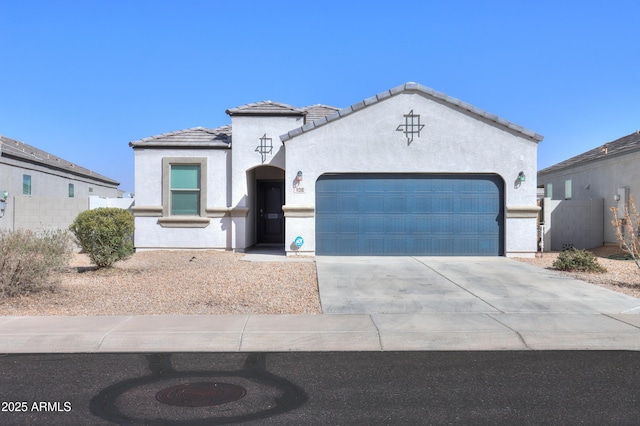 view of front facade with a garage, a tile roof, concrete driveway, and stucco siding