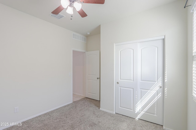 unfurnished bedroom with light carpet, baseboards, visible vents, and a closet