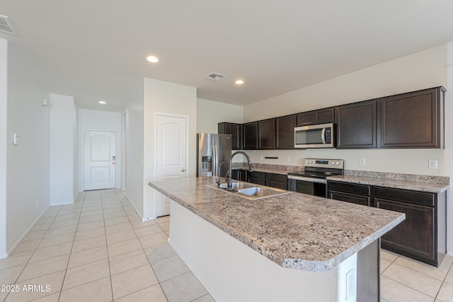 kitchen with light tile patterned floors, visible vents, appliances with stainless steel finishes, dark brown cabinets, and a sink