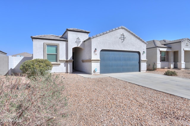 view of front of property featuring a garage, concrete driveway, a tile roof, and stucco siding