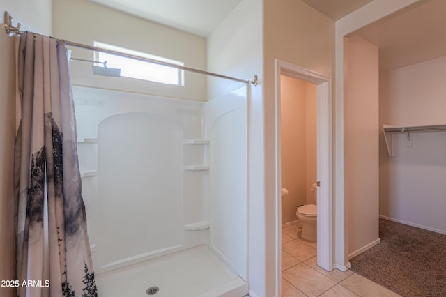 full bathroom featuring baseboards, a shower stall, toilet, and tile patterned floors